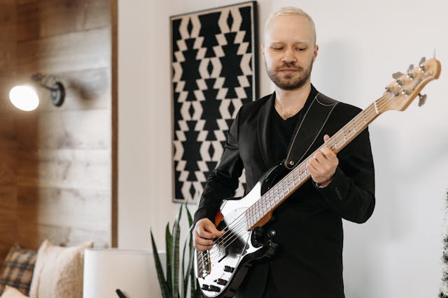 Mann spielt schwarzen E Bass – Symbolbild für E Bass lernen für Anfänger